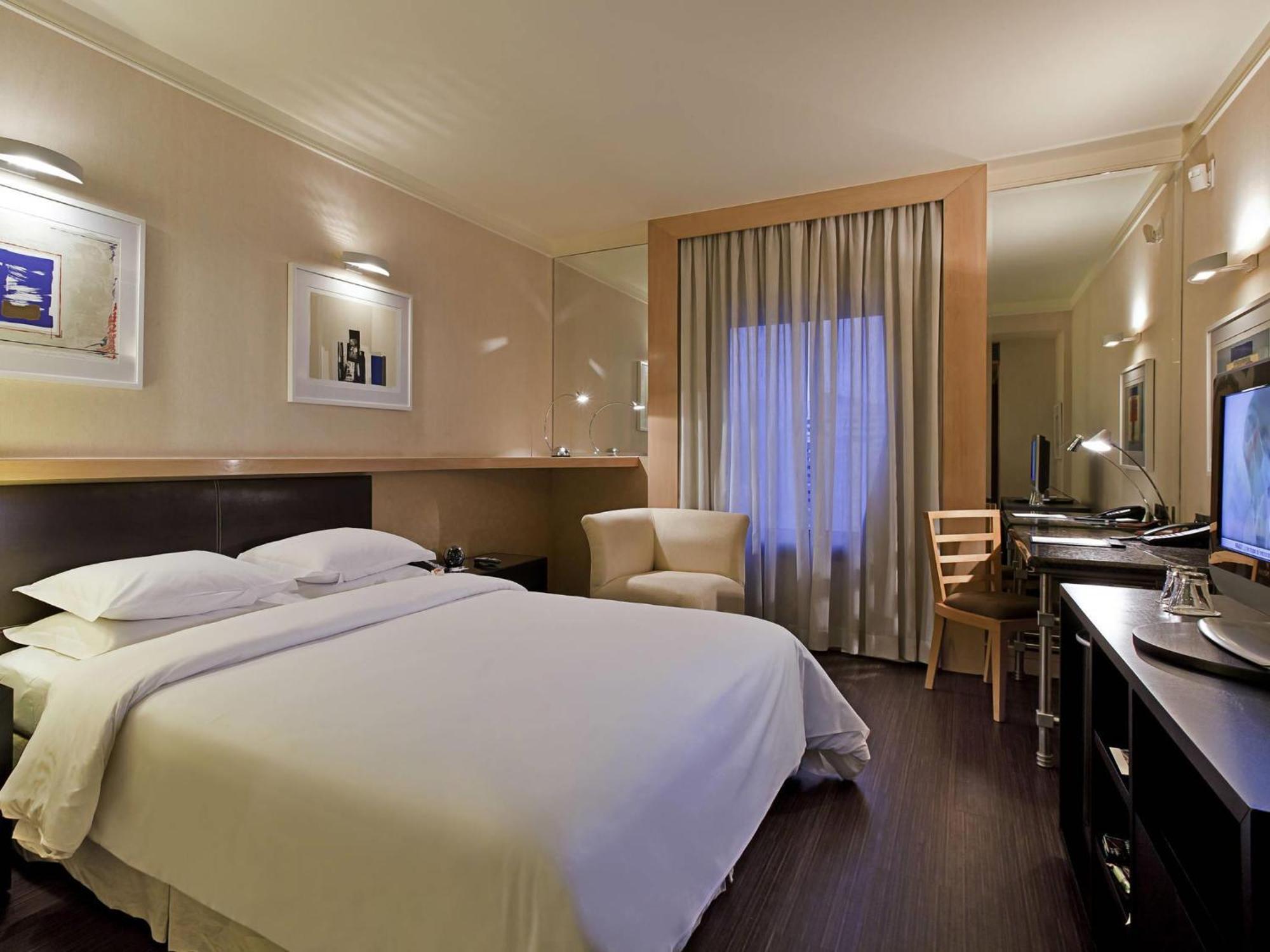 Quarto superior com cama queen size e vista da cidade